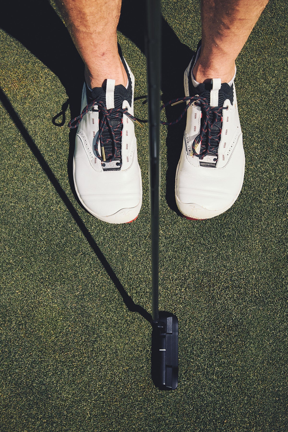 Looking down at WIN36 golf shoes at address, showing the wide toe box