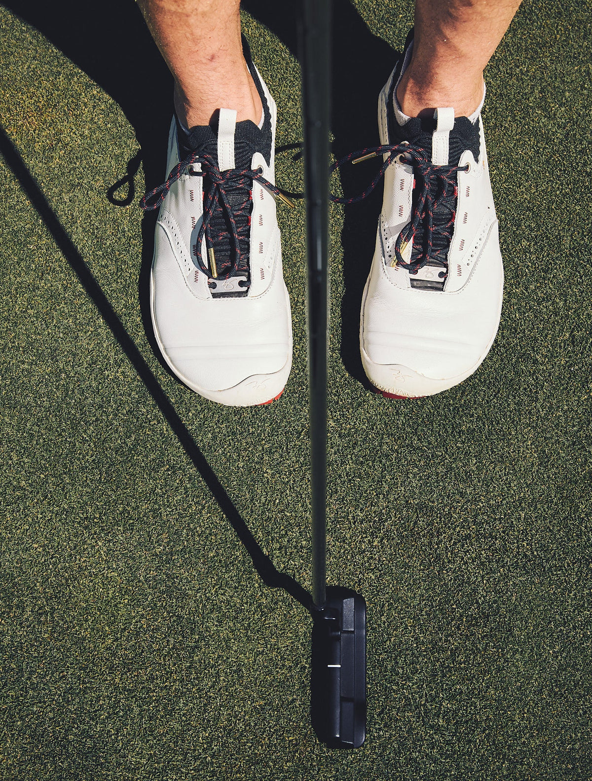 Looking down at WIN36 golf shoes at address, showing the wide anatomical toe box