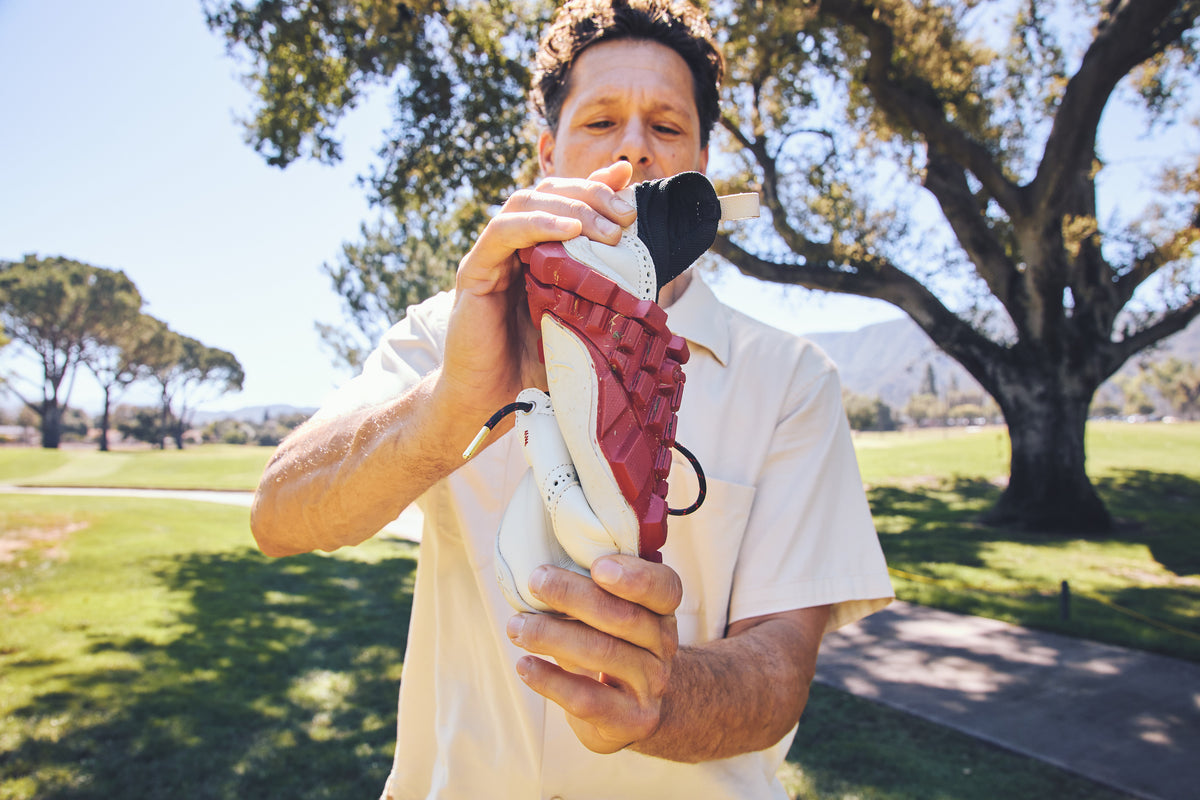 Founder twisting a WIN36 shoe to show how the sole flexes