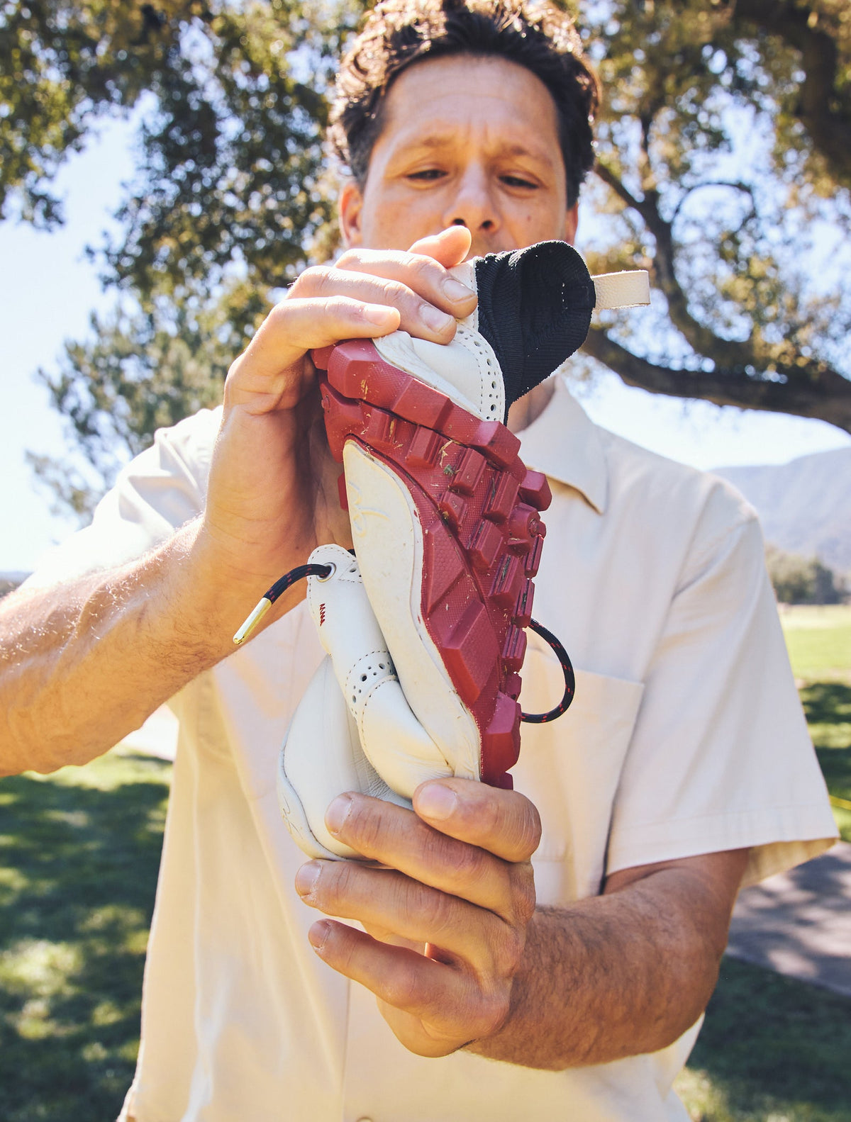 Founder twisting a WIN36 golf shoe to show the flexible sole